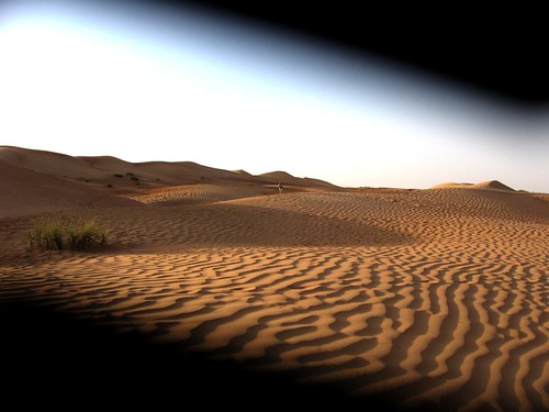 Desert sand ripples through a trapped camera lens
