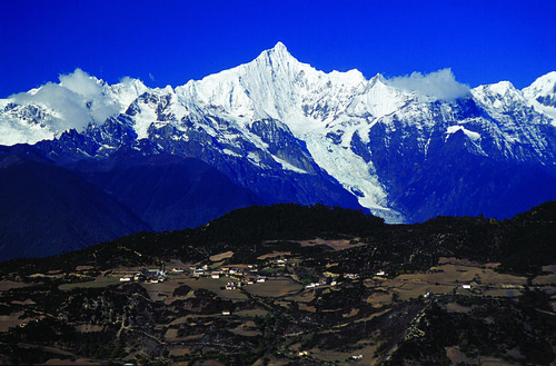 The sacred Khawa Karpo Peak looms above Feilaisi village in northwest Yunnan. Photograph by Robert Moseley.