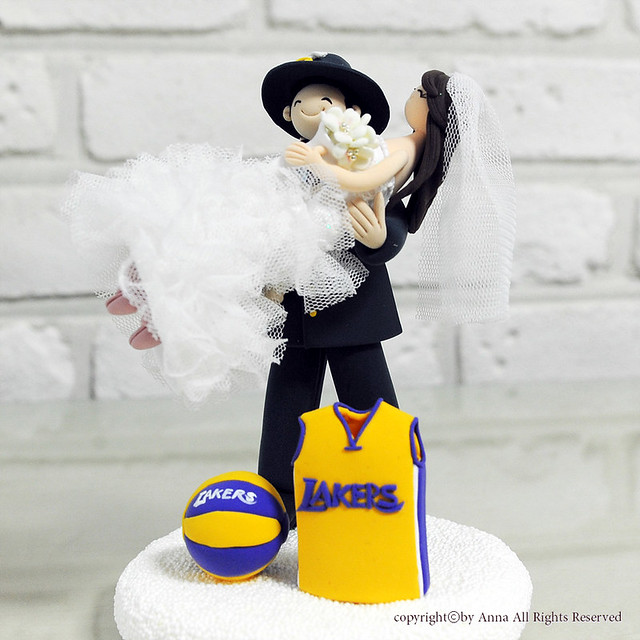 Firefighter with his bride and LA Lakers uniform wedding cake topper