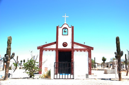 Rural Mexican church, white with red trim, adobe, bell, arch, cross, white sand, Saguaro cactus, graveyard, blue sky, Baja California Sur, Mexico by Wonderlane