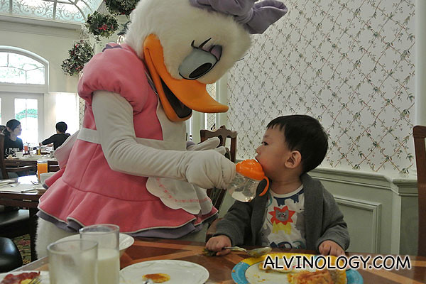 Daisy Duck feeding water to Asher