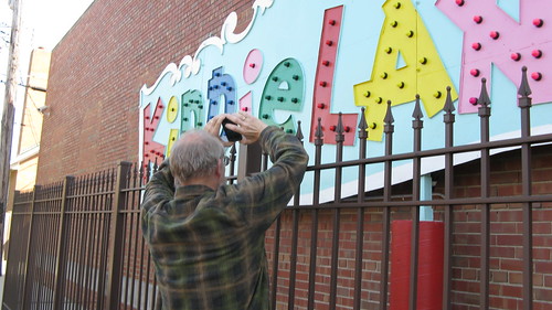 Mike Mikrut photographs the preserved portion of the old Kiddieland Amusement Park sign at the Melrose Park Public Library building. by Eddie from Chicago