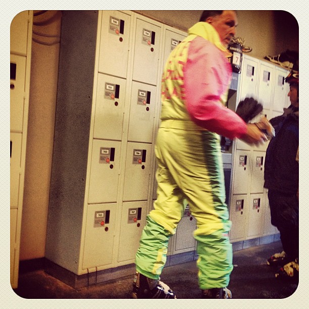 Retro ski fashion-- a full neon jumpsuit with "Free to good home" taped on back