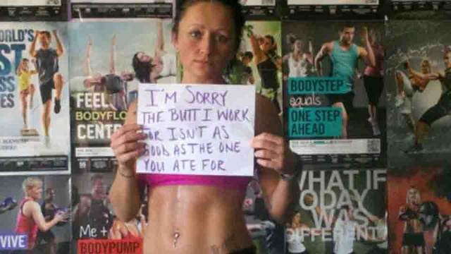woman holding a sign reading "I'm Sorry the Butt I Work For Isn't As Good as the One You Ate For"