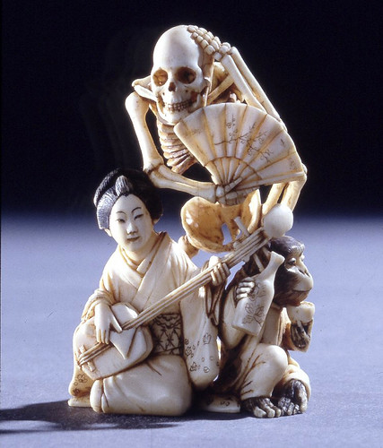019- Netsuke esqueleto con abanico detrás de la mujer que toca el samisen y un mono que bebe sake-Hecho de marfil-realizado por Gyokkosai -© Trustees of the British