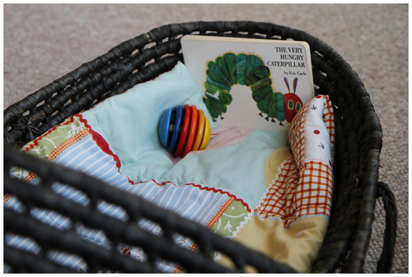 Preparing for baby: moses basket with book and baby toy