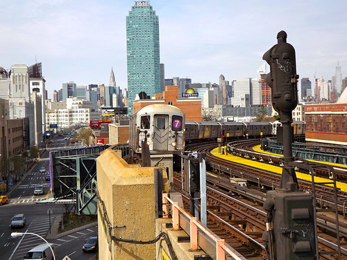 Manhattan in the background, with the 7 train approaching 33 St-Rawson St Station