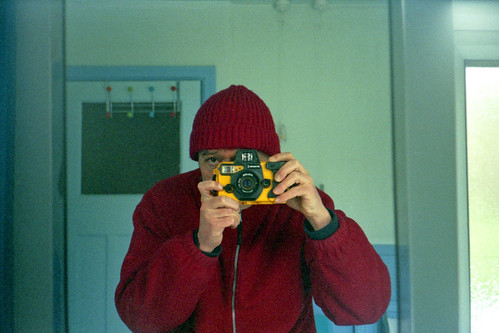 reflected self-portrait with Motormarine II camera and red hat by pho-Tony