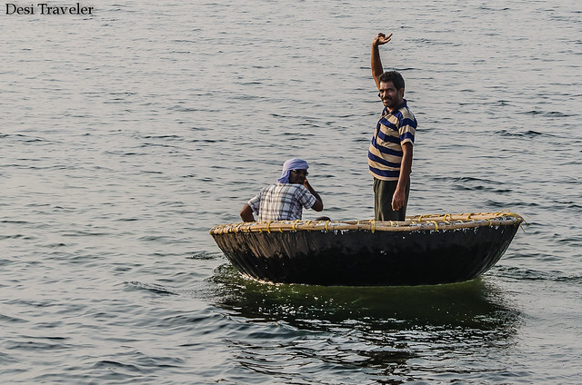 man standing and waving in a coracle made of bamboo 