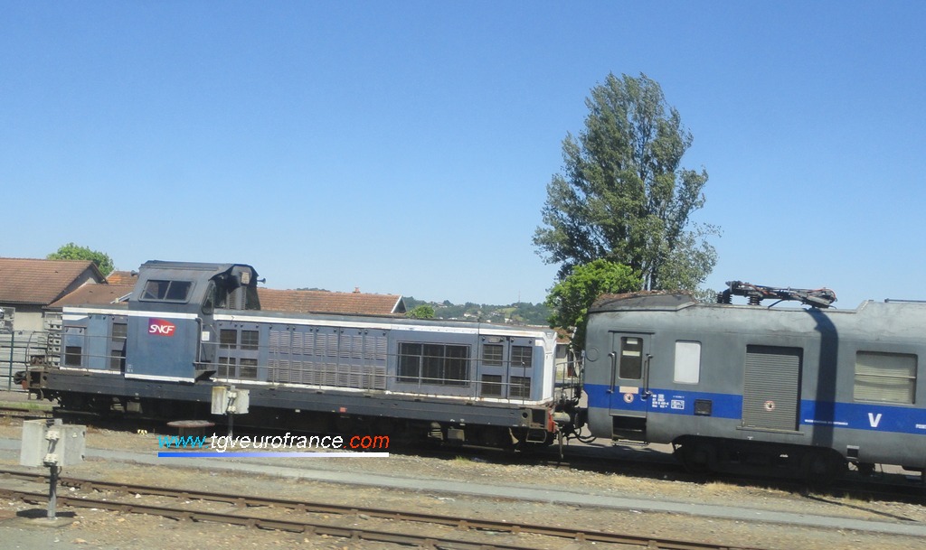 Une locomotive thermique BB 66000 de l'activité INFRA SNCF stationnant avec un wagon graisseur de caténaires