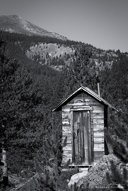 Colorado outhouse photo in black and white, of a primitive rustic privy located in the alpine ghost town of Independence, Colorado.