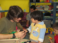 Colt Duttweiler interacts with a small child in the nursery at the La Limonada school