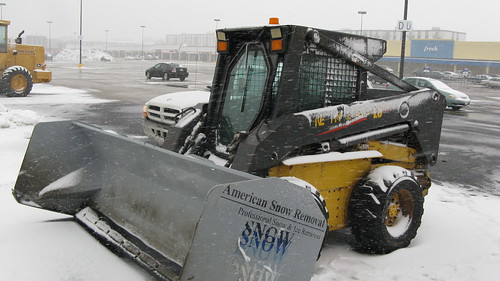 A little skid steer tractor with a huge snowplow attatchment.  Niles Illinois.  Tuesday, March 5th, 2013. by Eddie from Chicago