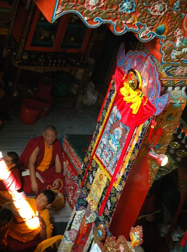 Lama Jampa under a thangka, a beam of light coming in from above, silk decorations, Sakya Lamdre, Tharlam Monastery of Tibetan Buddhism, Boudha, Kathmandu, Nepal by Wonderlane
