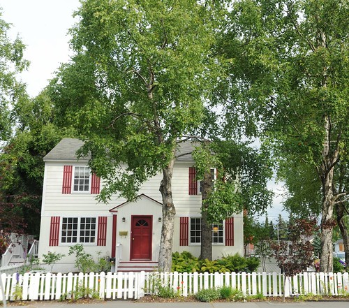 Red and White saltbox style house, white picket fence, birch trees, spruce trunk, "I" street, downtown, Anchorage, Alaska, USA by Wonderlane