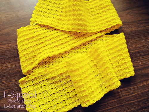 Bright yellow scarf made up of a stitch texture that looks and feels like tiny flower petals.