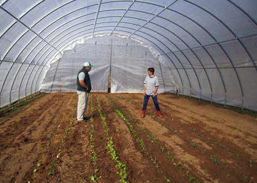 Johnson County, Tenn. District Conservationist, Jason Hughes, talks with landowner Janet Mahala about her recently constructed high tunnel. NRCS photo by Michelle Banks.