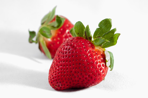 Two strawberries isolated on white background by DigiDreamGrafix.com