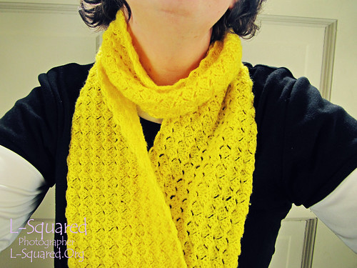 Yellow petals scarf being modeled around a person's neck. 