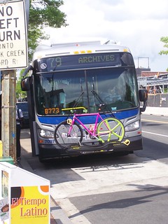 Bicycle in the bike rack on the front of a bus