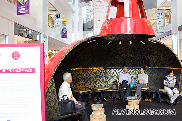 Red lampshades for shoppers to rest their feet (old folks not part of exhibit)
