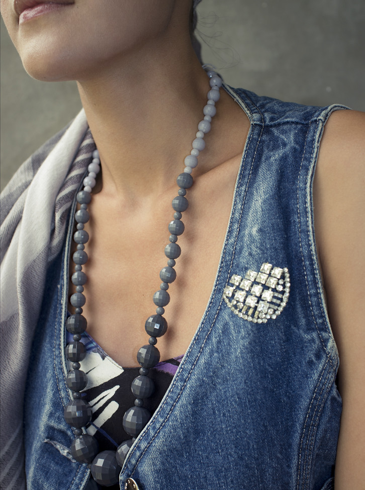 Mix up your accessories! In this photo, a graduated grey beaded 1980s necklace sits next to a 1940s rhinestone brooch.
