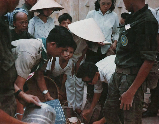 Page 163 - Hướng đạo sinh giúp phân phát lương thực cho nạn nhân chiến cuộc