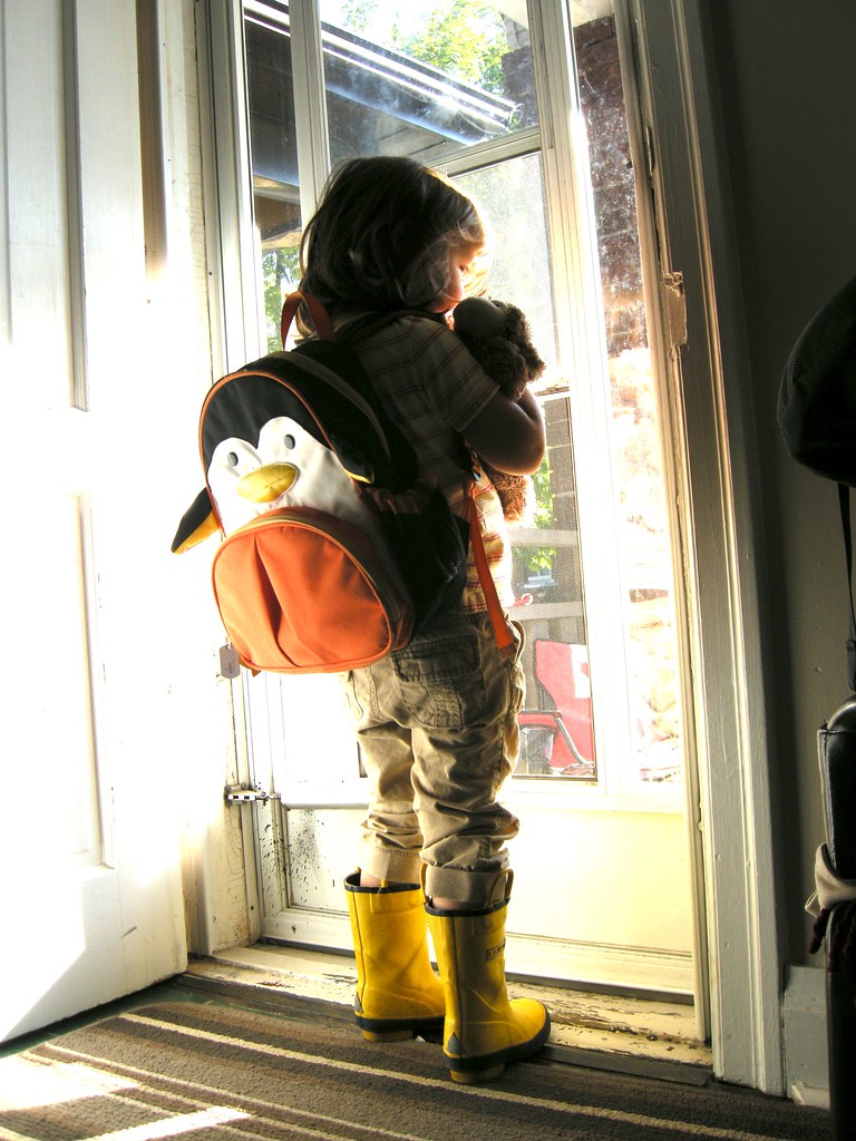 photo of a child with a backpack ready to head out the door to school