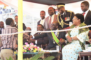 President Mugabe greets sungura artiste Alick Macheso after his performance at the Zimbabwe Defence Forces Day cele­brations at the National Sports Stadium in Harare while Vice Presidents Joice Mujuru (right), John Nkomo (left) look on. by Pan-African News Wire File Photos