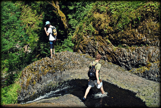 Hikers getting up close and personal with the edge of Triple Falls