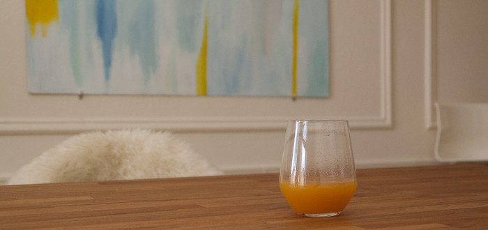 butcher block table, aqua painting, yellow accents, masonite painting, glass of peach juice