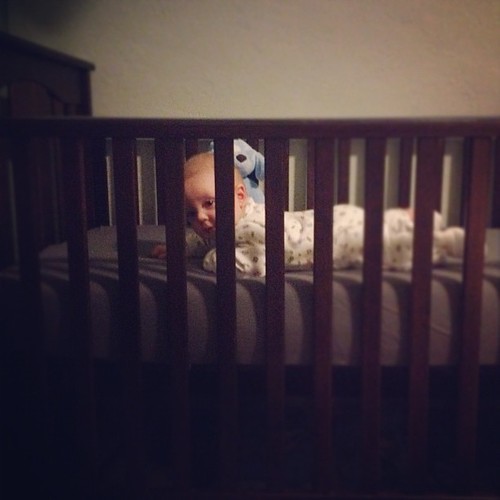 Watching his big brother from his crib.