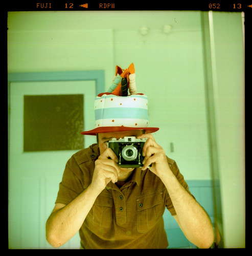 reflected self-portrait with Kodak 66 camera and novelty cake hat by pho-Tony