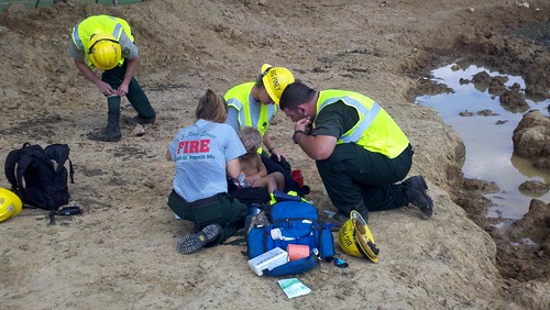 Rescue crews from the Ozark-St. Francis National Forest attend to three-year-old Landen Trammel whom they found Wednesday, Sept., 12 in Stone County, Ark. From left are Jamie Martin, Carol Swboni and Bradley Taylor who spotted the toddler playing in a mud puddle.  Photo credit: Courtesy of Fox16.com 