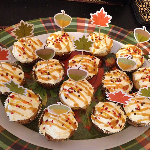 Apple spice cupcakes with apple pie filling in the middles and buttercream frosting with a caramel drizzle and autumn leaves sprinkles