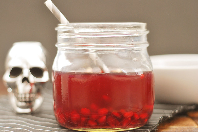 Bloody Tooth Cocktail - the creepiest cocktail for your Halloween party! Pomegranate juice and whiskey with pomegranate arils to look like bloody teeth!