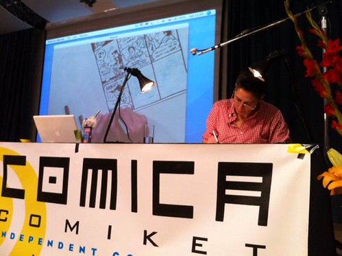 comiket drawing with screen in background