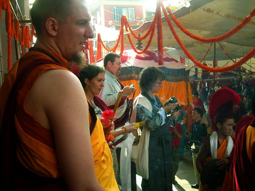 Students, monks, lay people with cameras and offerings, White Umbrella, marigolds, Sakya Lama procession, Tharlam Monastery Courtyard, Boudha, Kathmandu, Nepal, photo by Steve D. by Wonderlane
