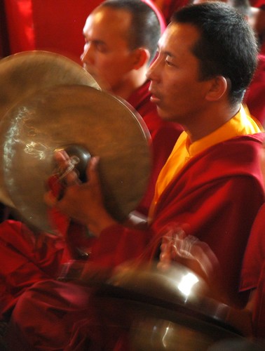Tibetan Buddhist monk plays cymbals during music offering, vibrating everything, traditional red and yellow robes, Sakya Lamdre, Tharlam Monastery, Boudha, Kathmandu, Nepal by Wonderlane