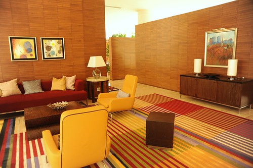 Lounge room, sofas, pillows, armchairs, end tables, lamps, art, sideboard, wood walls, striped carpet, red and yellow, contemporary furniture, Renaisance Hotel, Schaumburg, Illinois, USA by Wonderlane