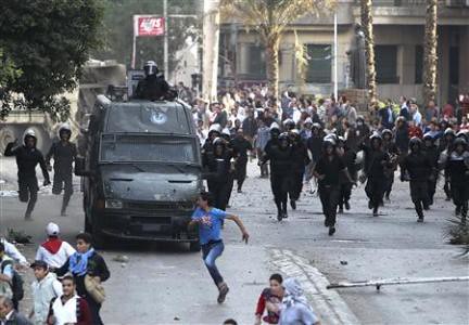 Egyptian riot police chase demonstrators in Cairo amid anti-dictatorship protests in November 2012. Thousands are opposing the Muslim Brotherhood government. by Pan-African News Wire File Photos