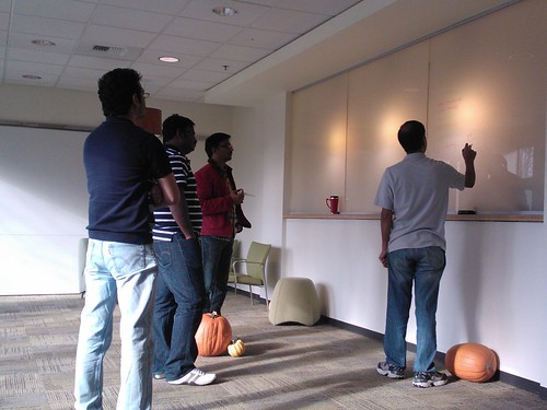 Sr program manager, pumpkins at his feet shares insights on Excel 2013, planning a new application, giving instruction on transparent lighted panels, to a group of programers, program managers, consultants, Redmond Town Center, Washington, USA by Wonderlane