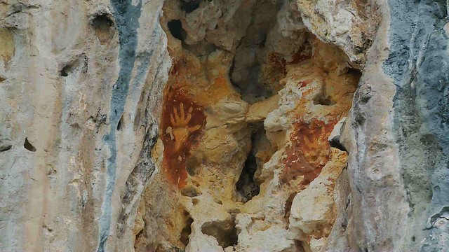 Cap tangan kuno di tebing sebuah pulau di dekat Teluk Kabui, Raja Ampat - Dok. Kompas TV