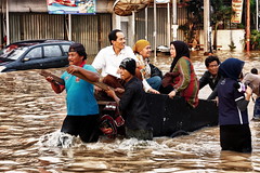 雅加達居民在洪水中涉水而過，2013年1月。(攝影：Ragil Tacilius)