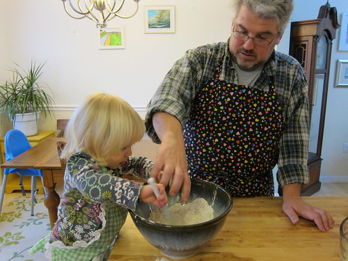 Momo getting excited about mixing while Dad deflects ingredients flying out of bowl
