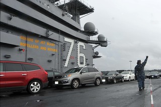 USS Ronald Reagan transports Sailor's cars during a port change.