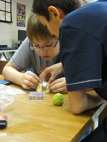 Two children concentrating on a squishy circuits creation on a table