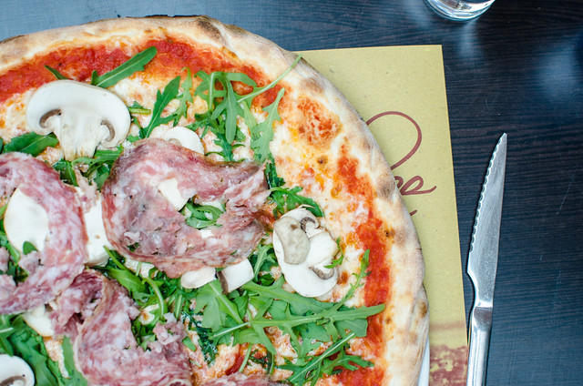 Pizza topped with salami and arugula in Venice.