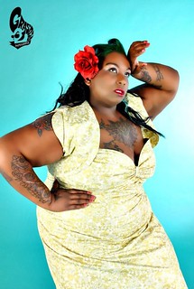 a woman in a yellowish dress with tattoos showing