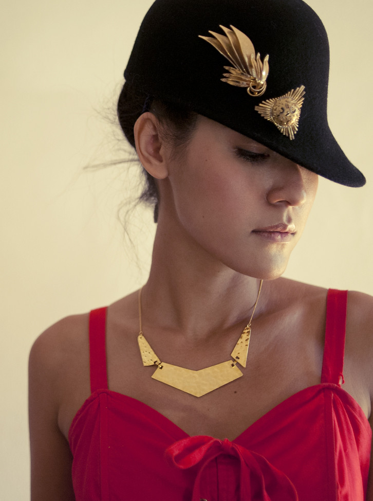 Make it loud, make it count! Awesome 1960s gilt brooches worn on a hat, and a hammered gold-toned choker around the neck. 